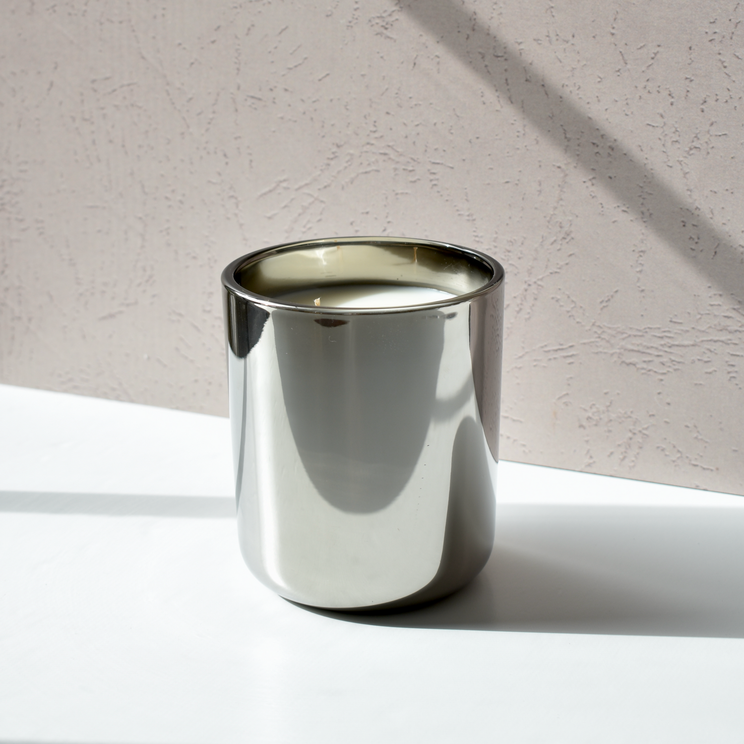 metallic gunmetal candle vessel infused with a spicy vanilla and tobacco fragrance