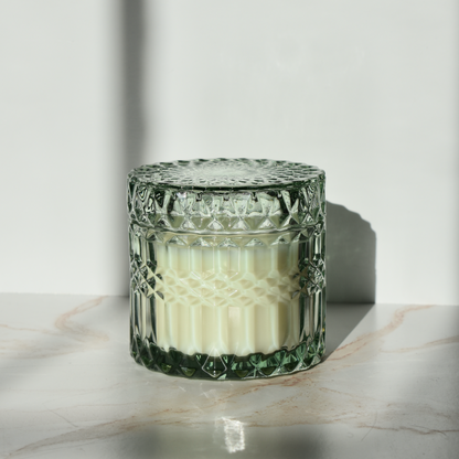 holiday candle in mint colored antique-style chunky glass vessel with lid. winter fragrance.